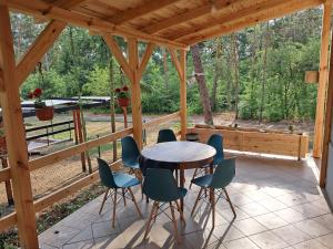 a wooden porch with a table and chairs on it at Leśne Zacisze in Wijewo