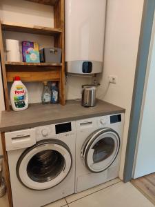 a kitchen with a washing machine and a microwave at Ferienwohnung Waldblick mit Balkon nahe Therme Loipersdorf in Windisch Minihof