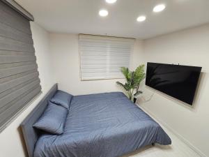 a bedroom with a bed and a flat screen tv at Terrace House Hwagok station in Seoul