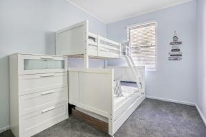 a white bunk bed with a ladder in a room at Baden 58 - Rainbow Shores. Aircon. Wifi. Pools Walk to beach in Rainbow Beach +6 photos