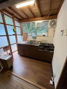 uma grande cozinha com um lavatório e um fogão em さぬきリトリート 繋安芯堂 em Kawashima