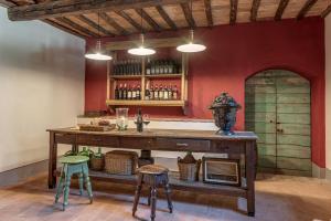un bar con una mesa de madera y dos taburetes en Villa dei fiori, en Castelfiorentino