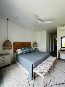 a bedroom with a bed and a bench in it at Face a l'ocean et au Coin de mire in Pereybere