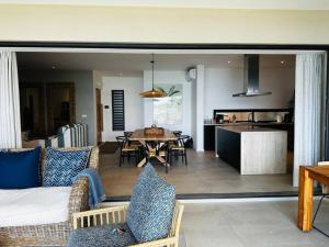 a living room and kitchen with a couch and a table at Face a l'ocean et au Coin de mire in Pereybere