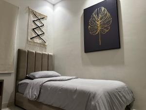 a bedroom with a bed and a picture on the wall at راكة سويت الخبر للشقق الفندقية المخدومة in Al Khobar