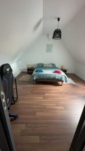 a bedroom with a bed and a wooden floor at En plein cœur du village Appartement lionceau in Riquewihr