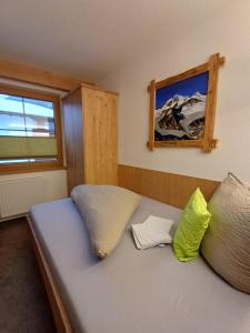 a bed with two pillows on it in a room at Haus Helene Prantl in Längenfeld