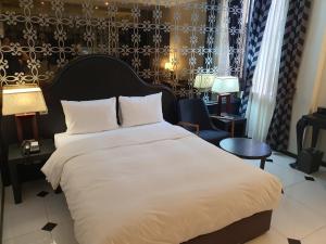 sypialnia z dużym białym łóżkiem i krzesłem w obiekcie Hotel Doma Myeongdong w Seulu