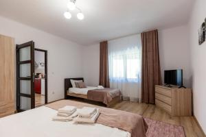 a hotel room with two beds and a television at Salt Orchid Apartments in Turda