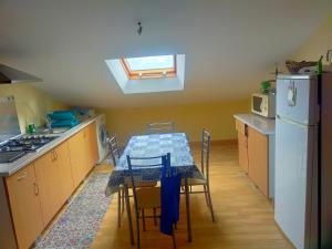 a kitchen with a table with chairs and a refrigerator at La Gaviota in Ferrol