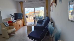 a living room with blue couches and a television at Canet playa y centro con free wifi in Canet de Mar