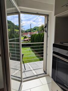 a sliding glass door with a view of a yard at Ferienwohnung Waldblick mit Balkon nahe Therme Loipersdorf in Windisch Minihof +18 photos