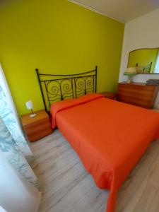 a bedroom with an orange bed and a green wall at Il MARE alla FINESTRA in Cavallino-Treporti
