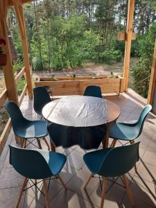 a table and chairs on a patio with a window at Leśne Zacisze in Wijewo +18 photos