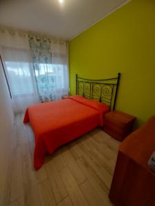 a bedroom with a red bed and green walls at Il MARE alla FINESTRA in Cavallino-Treporti
