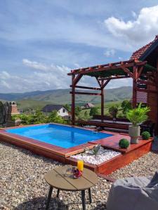 a swimming pool with a gazebo and a table at Rustic dream MIA in Zlatibor