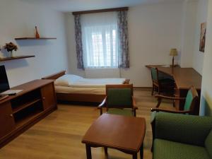 多瑙河畔克雷姆斯的住宿－Gästehaus Einzinger，客房设有一张床、一张桌子和椅子。
