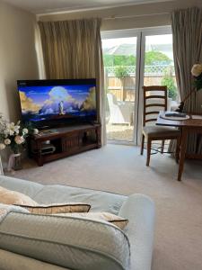 sala de estar con sofá y TV de pantalla plana en Highcroft House, en Corsham