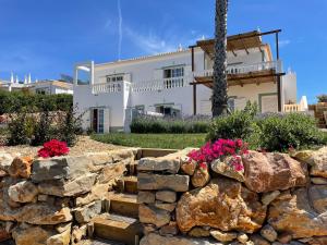 a stone wall in front of a house at Stunning Villa with Pool & View near beach in Budens
