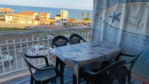 Canet playa y centro في كانيه دي مار: طاولة وكراسي على شرفة مطلة على ميناء
