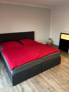 a bedroom with a red bed with a red blanket at Ferienhaus Soleblick in Bad Salzungen