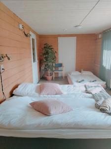 grupa łóżek w pokoju z drewnianymi ścianami w obiekcie B&B Villa Helmi w mieście Alatemmes