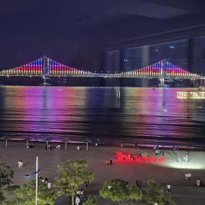 a bridge with purple lights over the water at night at Paradise on earth in Busan