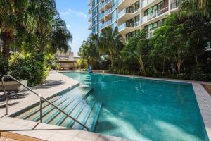 een zwembad in een gebouw met palmbomen bij Cityscape 2-Bed with Pool, Gym & Secure Parking in Brisbane