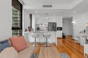 een woonkamer met een bank en een keuken bij Cityscape 2-Bed with Pool, Gym & Secure Parking in Brisbane