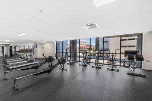 een fitnessruimte met diverse loopbanden en cardio-apparatuur bij Cityscape 2-Bed with Pool, Gym & Secure Parking in Brisbane