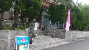 una señal frente a un edificio con bandera en Kami House en Amami