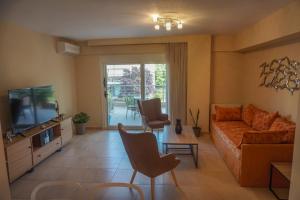 a living room with a couch and a television at EPIVATES FAMILY Apartment in Neoi Epivates