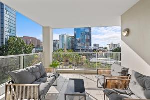 a balcony with couches and a view of a city at Prime City Residence with Pool, Gym and Parking in Brisbane