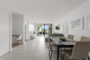 a dining room and living room with a table and chairs at Sleek City Apartment with Parking and Balcony in Brisbane