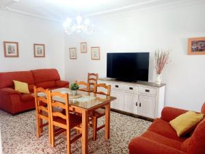 - un salon avec une table et une télévision dans l'établissement Piso Carmen Solo Familias, à Conil de la Frontera