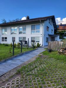 a white house with a fence and a yard at Ferienwohnung An der Kapelle in Rickenbach