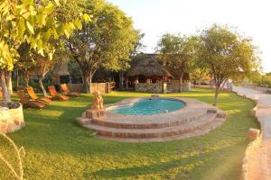 una piscina en un parque con cenador en Sophienhof Lodge en Outjo