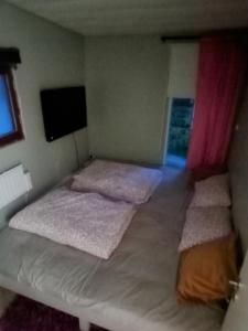 een kleine slaapkamer met 2 bedden en een raam bij Ackes Stuga 32 in Örebro