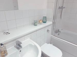 ロンドンにあるBattersea Chelsea Bridge Apartmentの白いバスルーム(トイレ、シンク付)