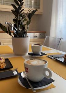 eine Tasse Kaffee auf einem Tisch mit einem Löffel in der Unterkunft Villa Hoff Wellness & Spa in Trzęsacz