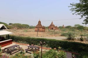 a group of benches and temples in a field at Temple View Hotel in Bagan