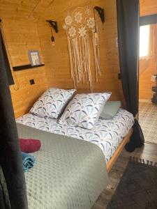 Una cama con almohadas en una habitación con paredes de madera. en Roulotte , hébergement atypique, en Solliès-Pont