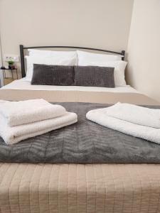 two white towels are laying on a bed at D&K Studio - Nafplio in Nafplio
