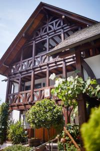 a large wooden building with trees in front of it at Weinhaus Lenz in Briedern