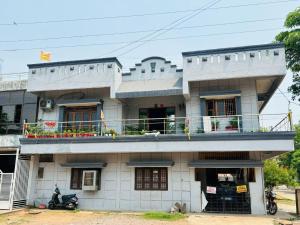 a white building with a balcony on top of it at Shukla Guest House in Durg