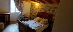 ein Schlafzimmer mit einem Bett in einem Zimmer in der Unterkunft maison du 13eme siècles in La Genétouze