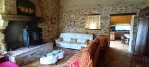 ein Wohnzimmer mit Couch und Kamin in der Unterkunft maison du 13eme siècles in La Genétouze