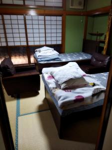 石巻市にあるPrivate Room 1 Japanese Vintage House 4 Beds, Smoke Free, Free Parking Good to Travel for Tashiro Cats Islandのベッド2台と窓が備わる客室です。