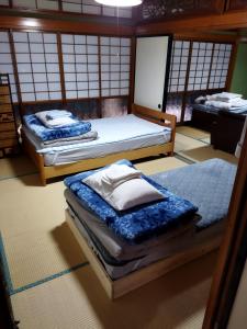 石巻市にあるPrivate Room 1 Japanese Vintage House 4 Beds, Smoke Free, Free Parking Good to Travel for Tashiro Cats Islandのベッド2台(1室につき1台)