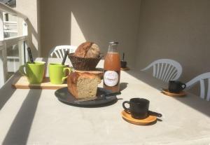 Una mesa con una hogaza de pan y una botella de salsa. en L'escale marine, en Pléneuf-Val-André